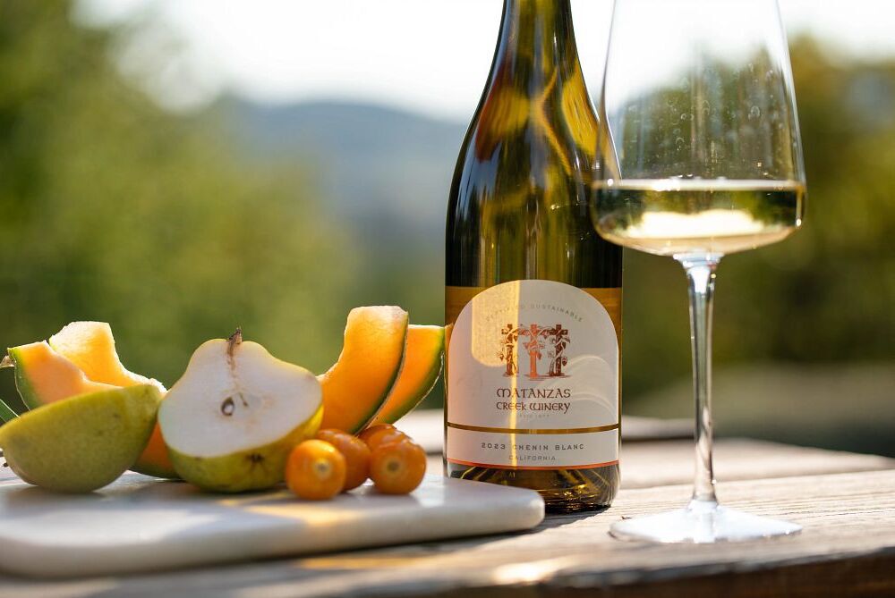 A bottle and glass of Matanzas Creek white wine with fruits